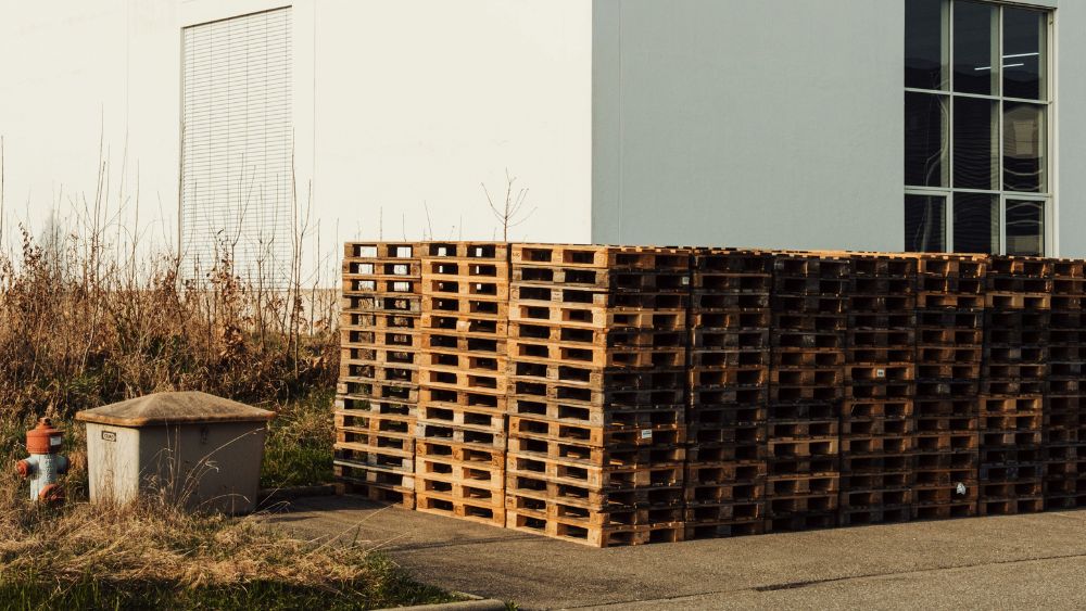 Close-up view of a vertical stack of refurbished hardwood pallets showing consistent board thickness and flush-driven nails